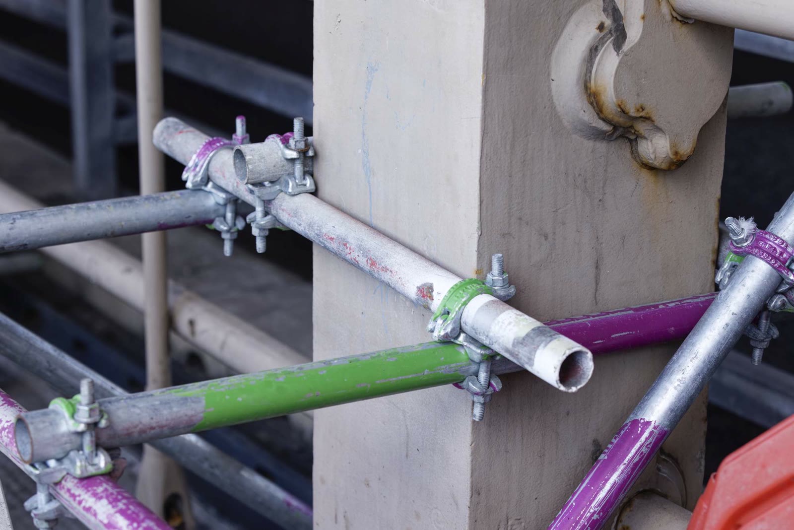 Close detail of scaffolding tube clamps fixed to a stone pier