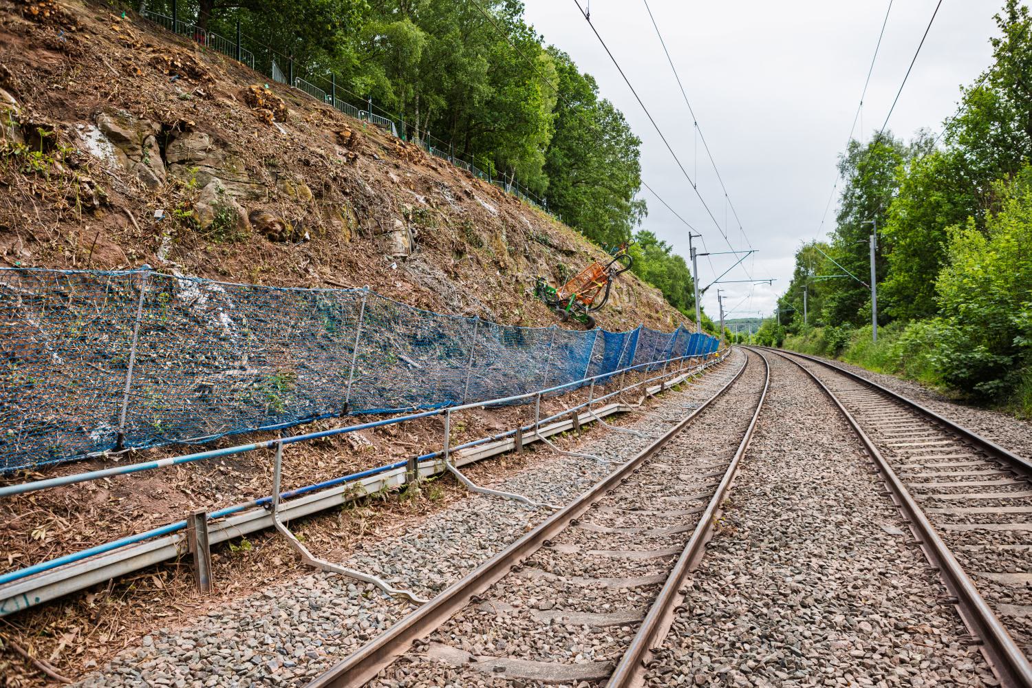 Ground-level view of the completed embankment reinforced with rock armour and mesh netting